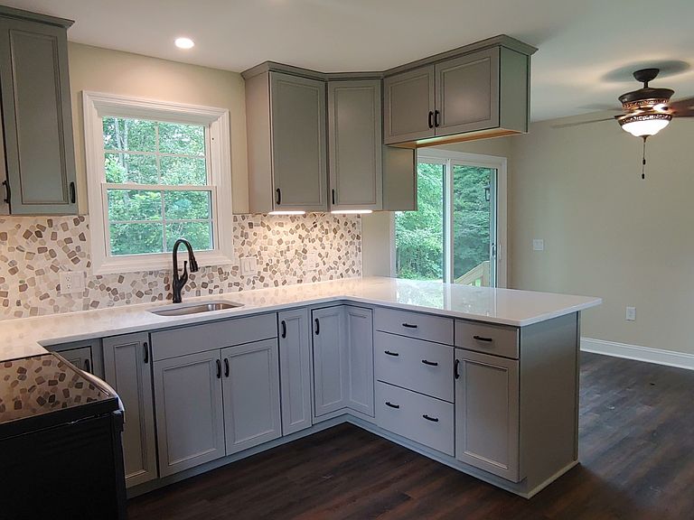 Completed sage green kitchen with modern hardware and finishes